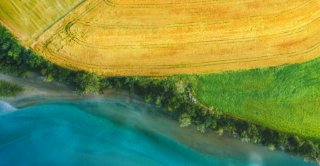 Aerial view above rural fields and Rauma river landscape in Norway top down scenery Romsdalen valley agriculture countryside